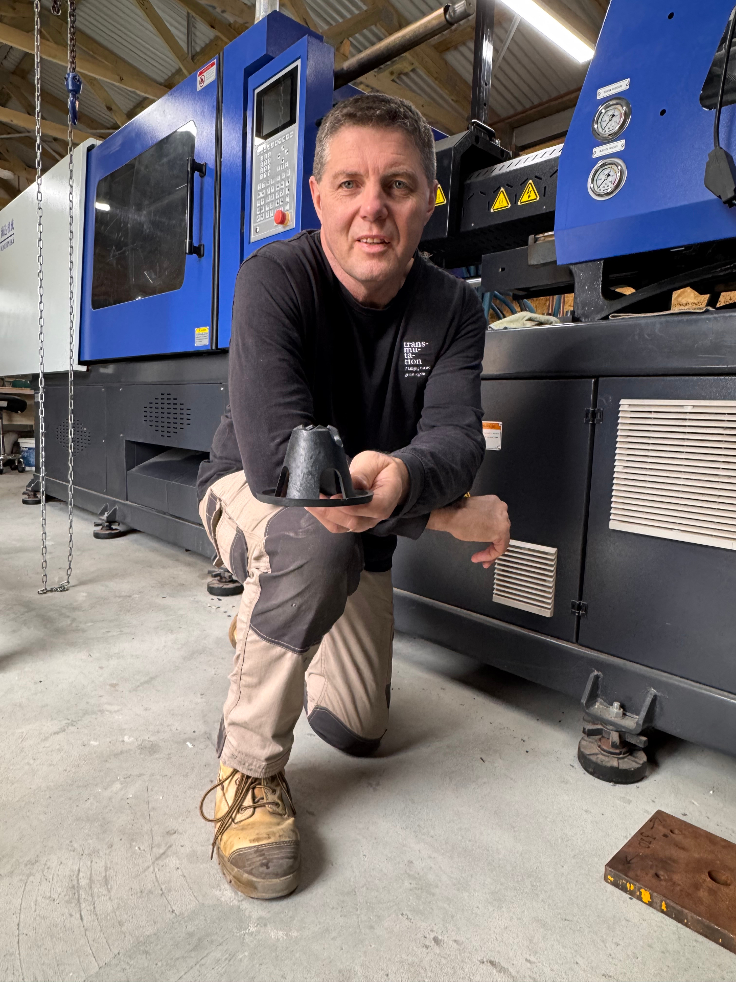 Transmutation founder holding a recycled plastic product in the manufacturing workshop