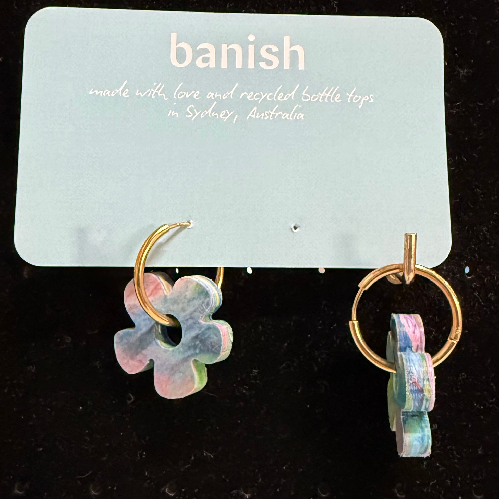Transmutation - Earrings in shape of a Daisy. Made from recycled plastic bottle tops in the colours of a rainbow with hoop made for pierced ears.