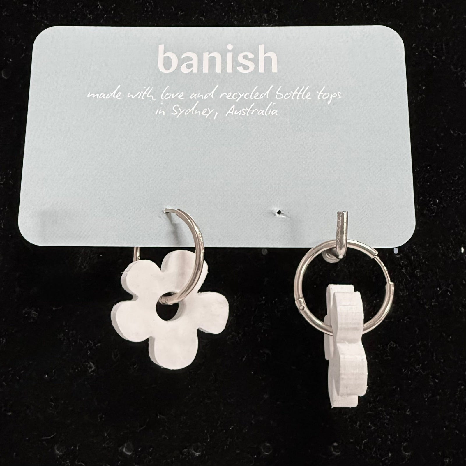 Transmutation-Earrings in a Daisy shape made by recycling black and white bottle tops.