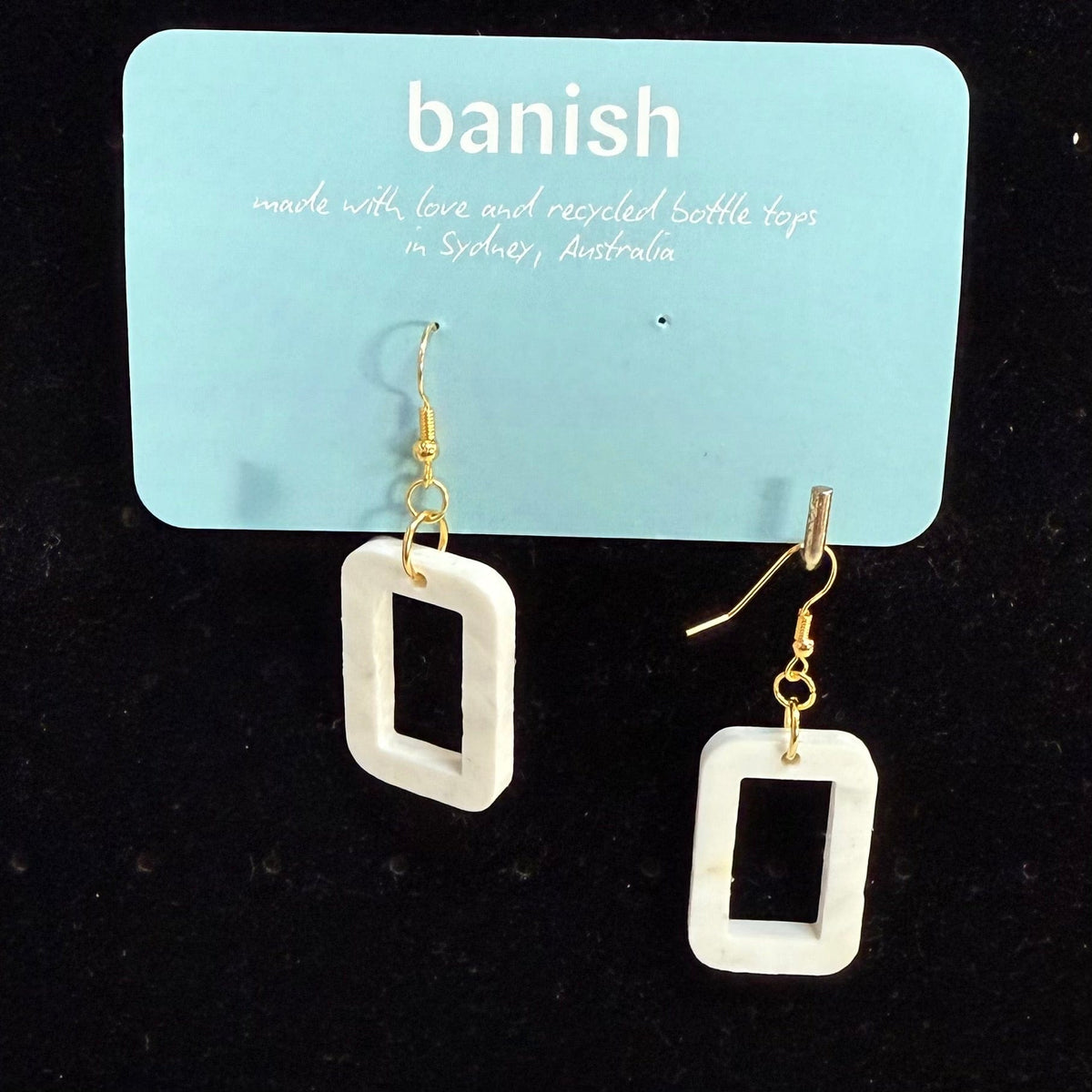 Transmutation - snow white, little windows of plastic that once were bottle tops, now stylish earrings with gold hooks for pierced ears.