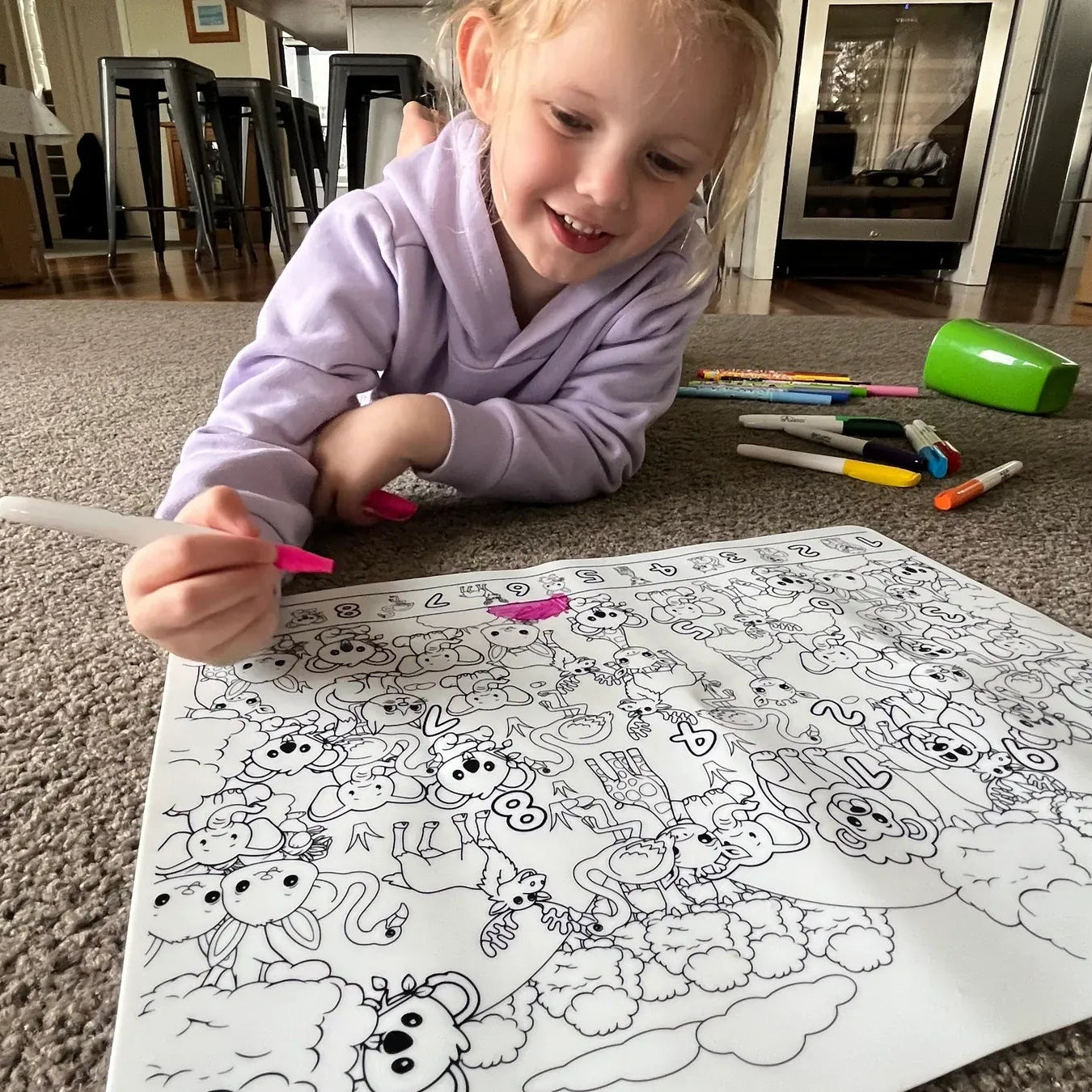 Transmutation-child on lounge room floor with a Colouring Mat that is reusable, just wipe clean after use.