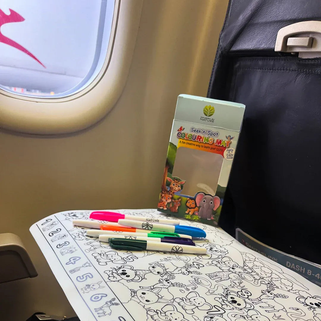 Transmutation-child on lounge room floor with a Colouring Mat that is reusable, just wipe clean after use.