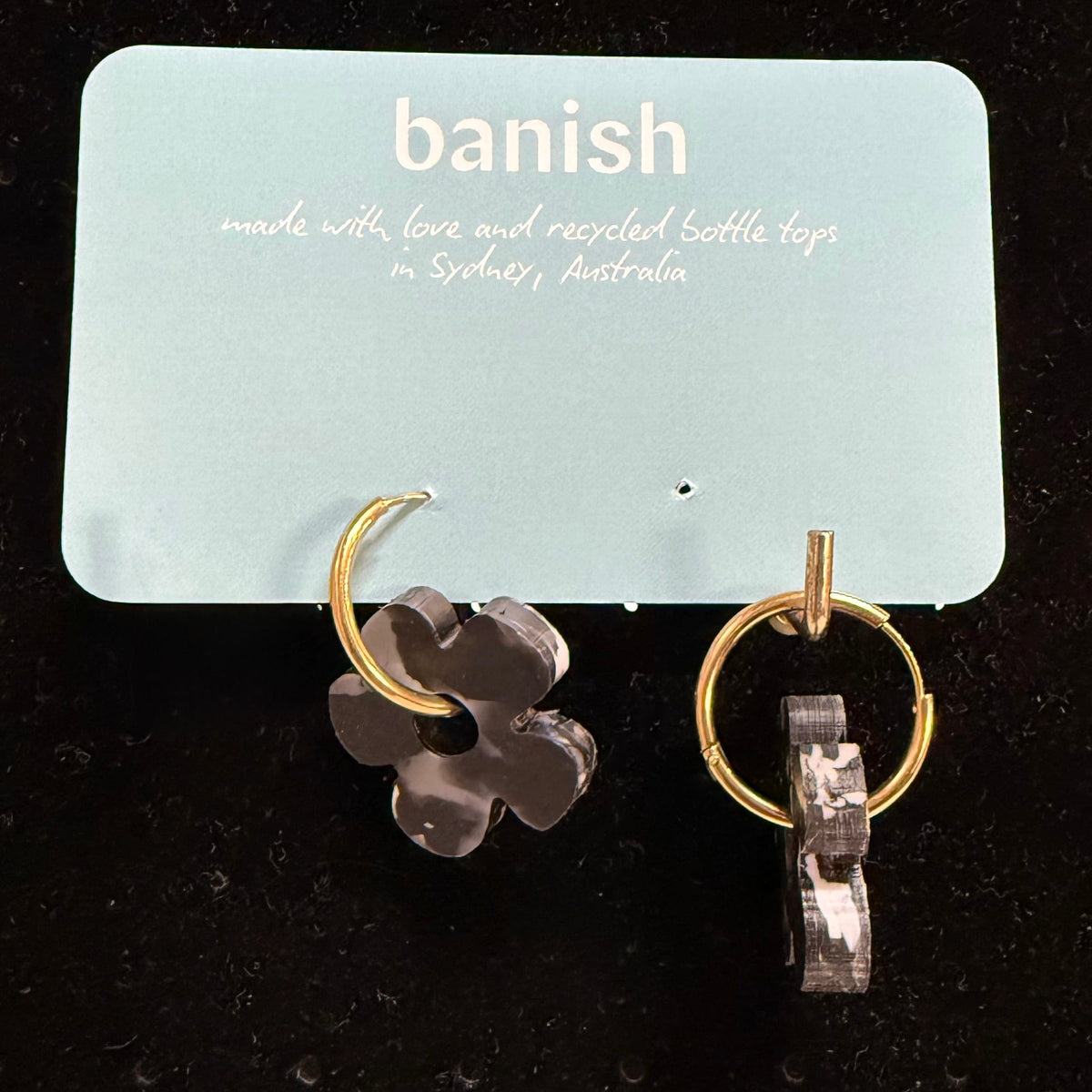 Transmutation-Earrings in a Daisy shape made by recycling black and white bottle tops.