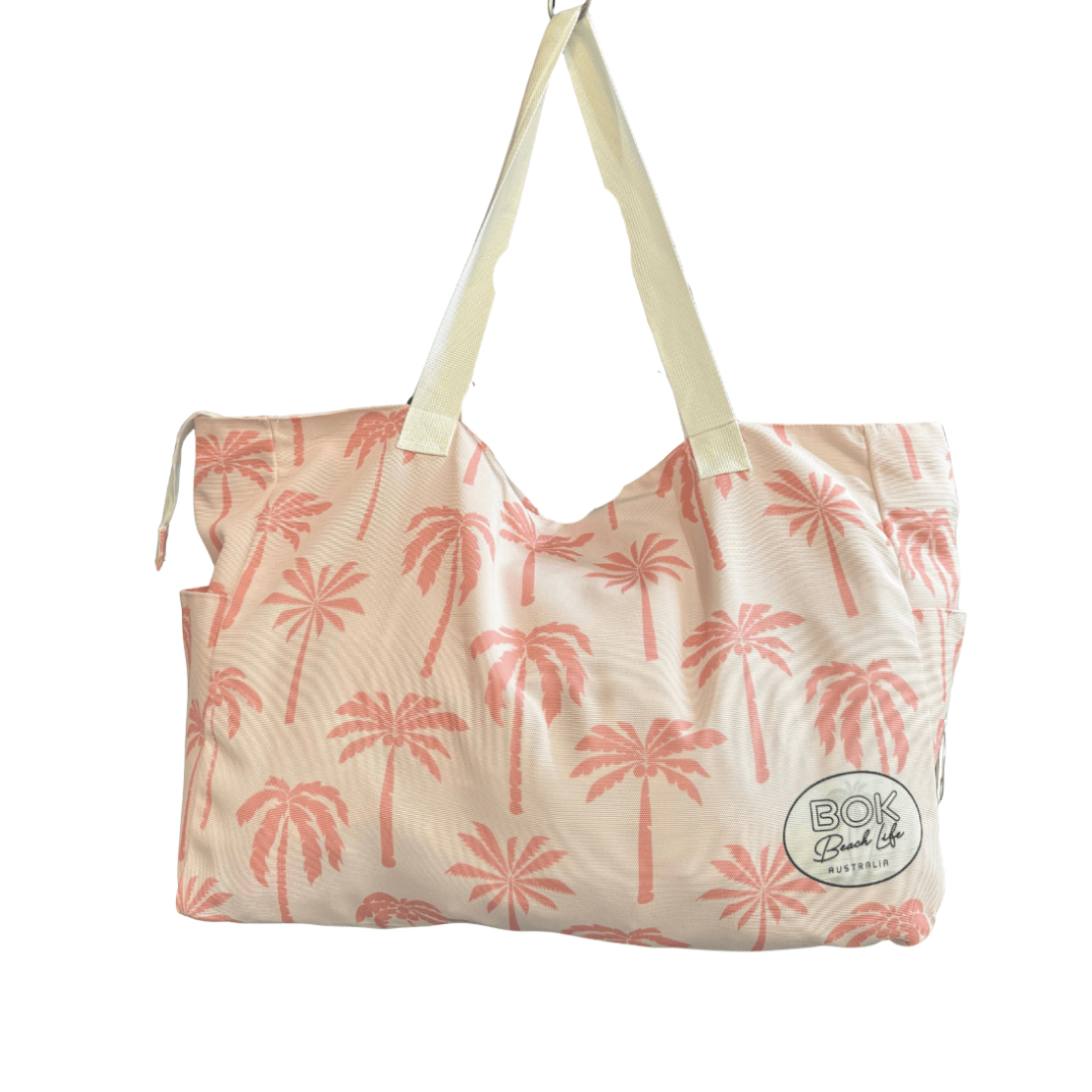 Transmutation - Beige tote bag with pink palm tree pattern and 'BOK Beach Life' logo on a white background