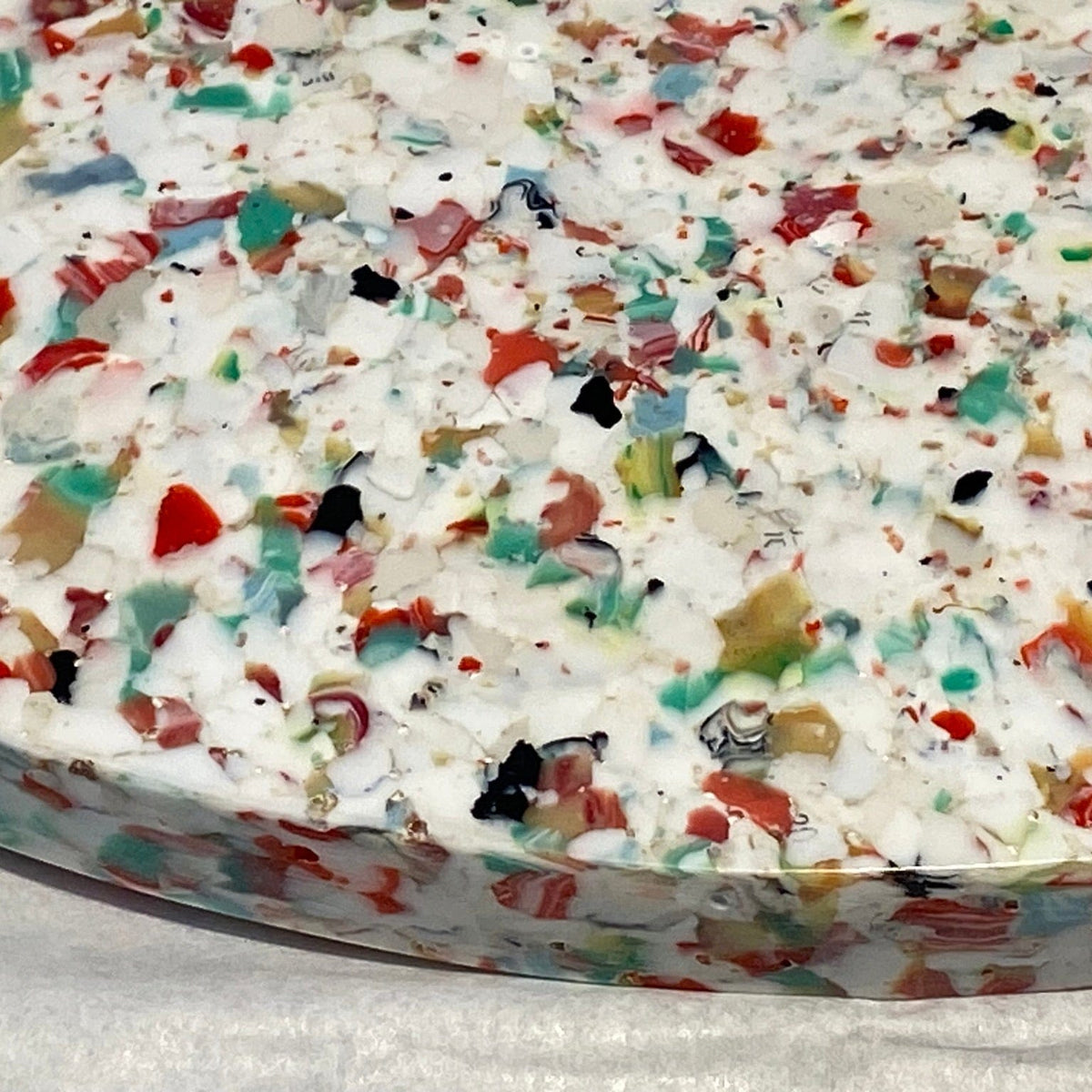 Transmutation lazy susan Lazy Susan - Terrazzo. Made from recycled polystyrene, bread tags, coat hangers and coffee cup lids.